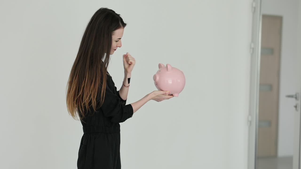 Woman looking at a piggy bank
