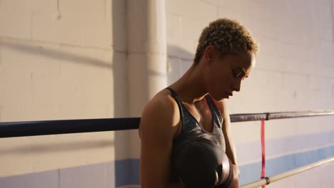 mixed race woman adjusting boxing gloves