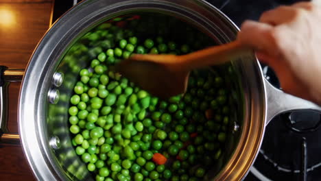 cooking peas and carrots in a pot