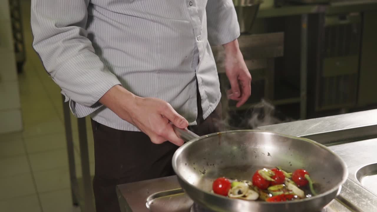 chef cocinando verduras en una sartén