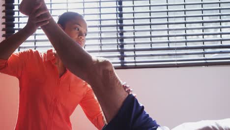 physiotherapist assisting man with leg exercise 4k