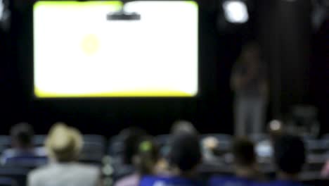 lecture in auditorium, speakerm defocused video, moving camera, panoramic motion