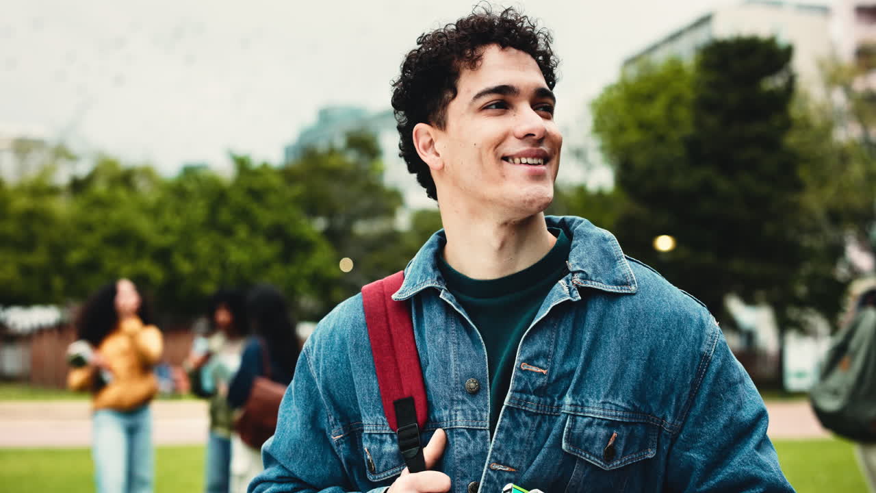 Joven con pelo rizado y chaqueta vaquera en el campus