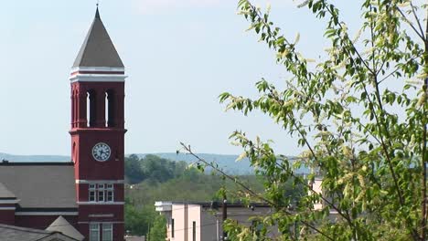 Treetop-Branches-Sway-In-The-Wind-In-Front-Of-An-Old-Clock-Tower