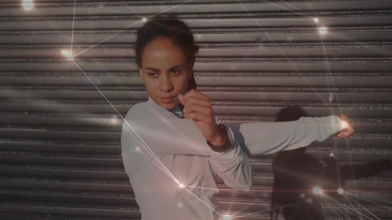 Woman initiating punch before shutter by leaning forward, sparkles and stretching for workout