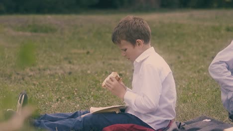 young guy reads book eating burger during lunch break