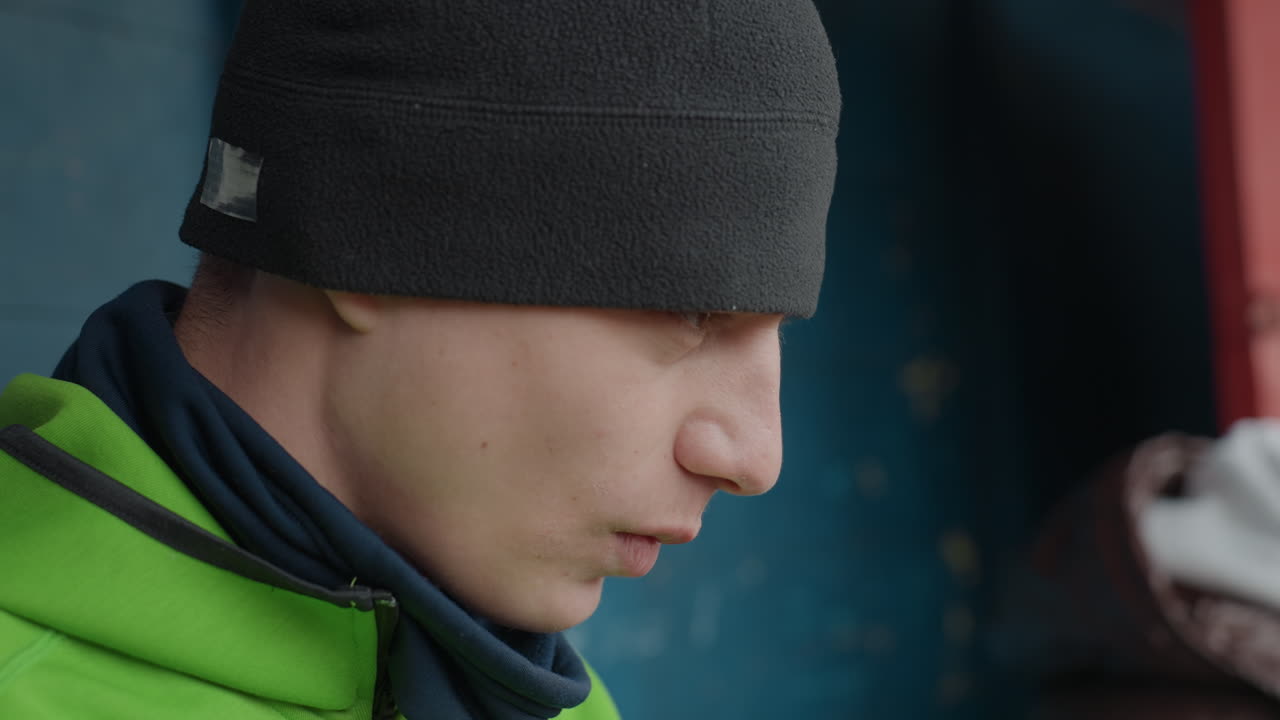 편안한 십 대 스포츠 참가자가 야외에서 캐주얼한 복장으로 게임을 즐기고 있어요. 젊은 선수가 편안한 옷차림으로 야외에서 친구들과 함께 편안함과 동료애를 보여주고 있어요.