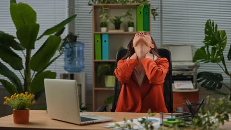 woman experiencing neck pain at her office desk