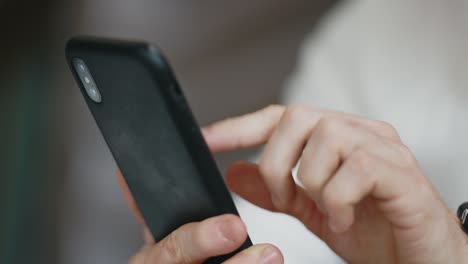 close-up of male hands using mobile phone