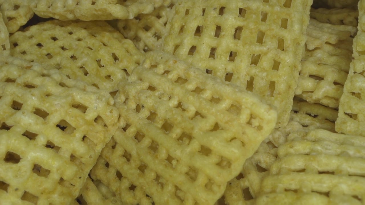 Toasted corn-squares cereal. Probe lens macro. Extreme closeup.