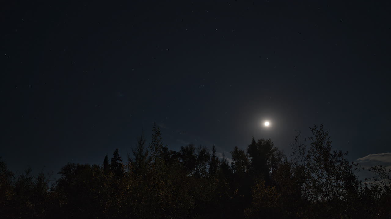 Timelapse del cielo notturno con la luna e le nuvole in movimento in 4K sopra Mauricie, Quebec, Canada. Stelle e chiaro di luna creano un'atmosfera serena e cinematografica