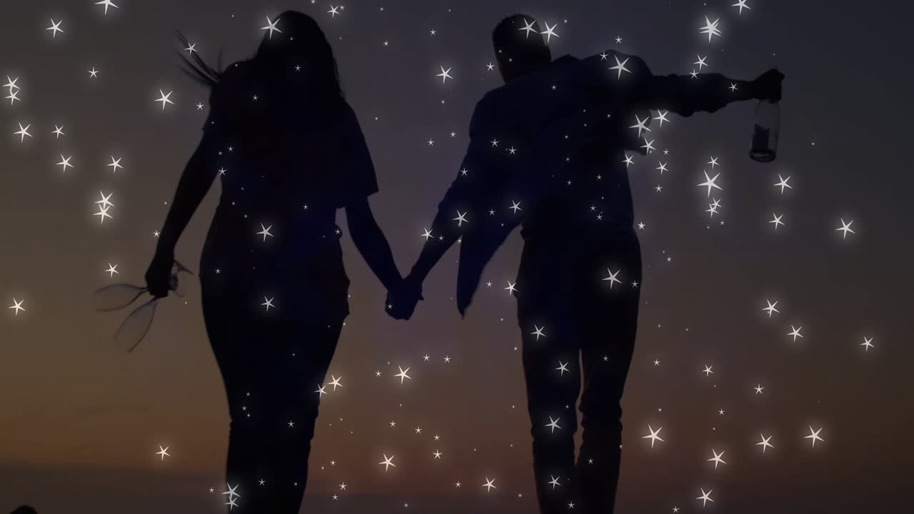 Sagome che entrano in scena e camminano mano nella mano per un film romantico con scintillii e il bagliore di una lanterna.