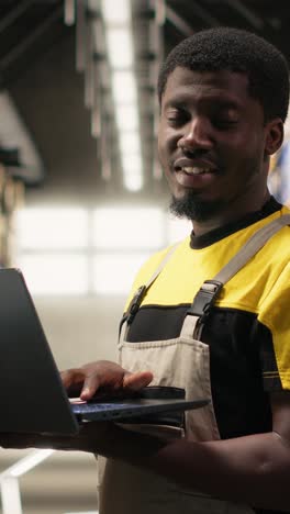 vertical video black male staff verifying inventory pallets in e-commerce logistics center
