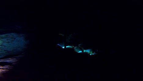 buceadores de cuevas en una oscura cueva submarina llamada cenote en méxico