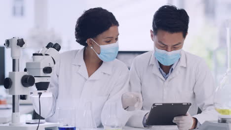 two medical scientists using a tablet