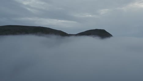 mysterious scandinavian landscape, mountains emerging from the clouds