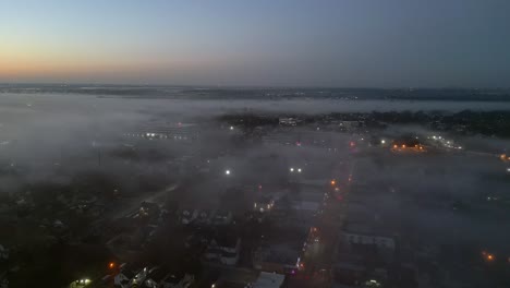 a wide angle, aerial view high above the fog during sunrise over long island, new york