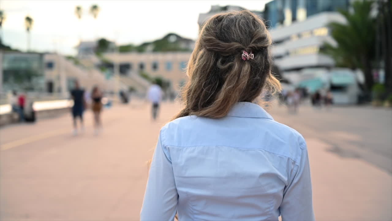 Cannes, França - 17 de fevereiro de 2022: Mulher de camisa azul caminhando pelas ruas da cidade