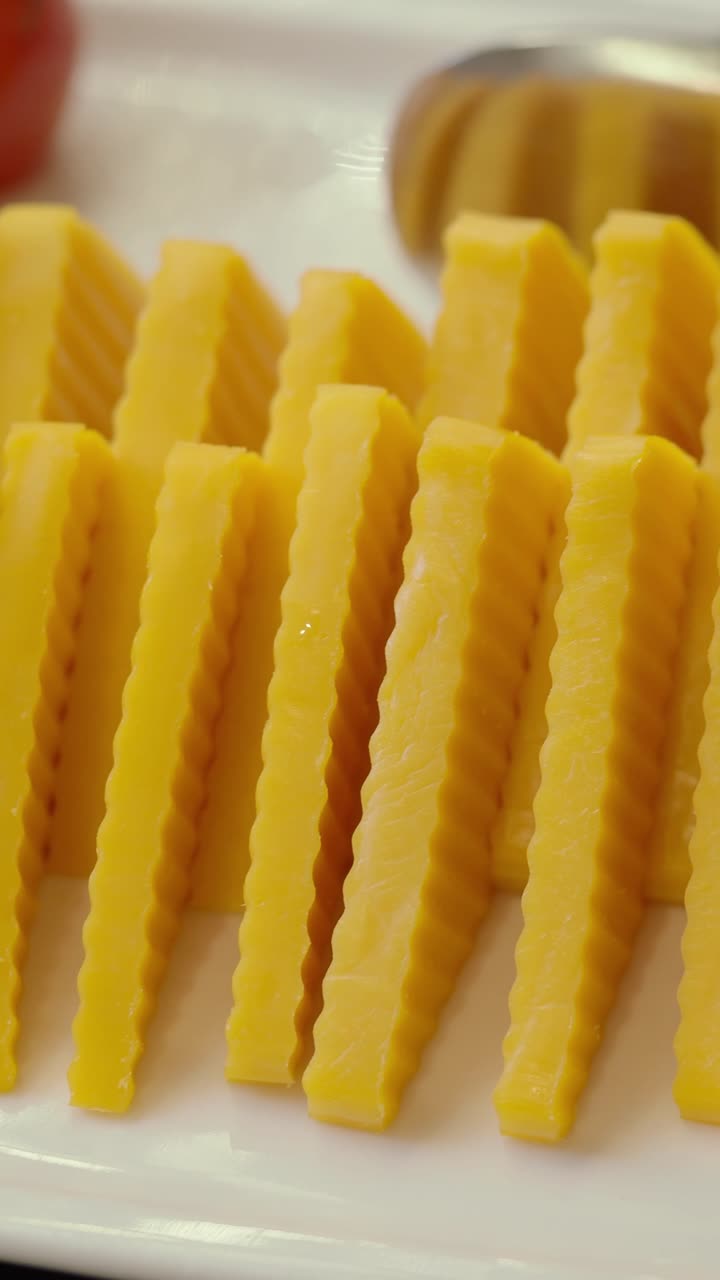 Primo piano di dessert giallo ondulato a fette su un piatto bianco