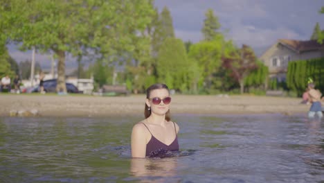 Junges-Attraktives-Mädchen-Mit-Sonnenbrille,-Das-Im-Wasser-Spielt