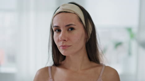 portrait tired woman touching skin in bathroom. unhappy lady checking wrinkles