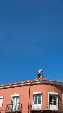 roof cleaning on a pink building