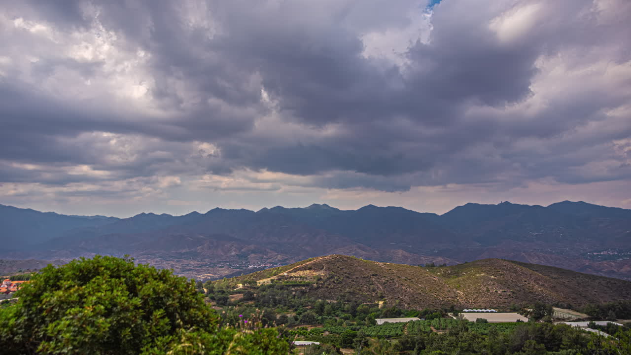lapso de tiempo de nubes oscuras que se mueven hacia la cámara con la silueta de la montaña en el fondo