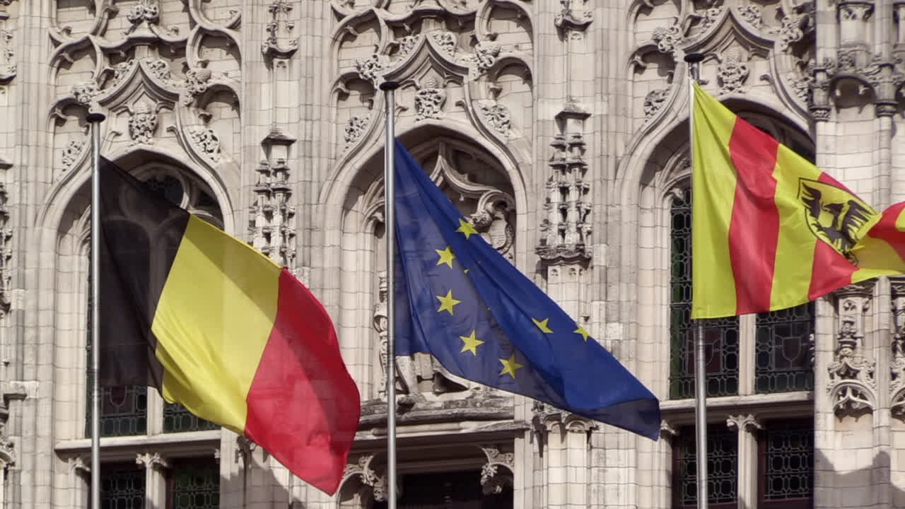 Mechelen, bandiera dell'UE e belga che sventolano davanti alla statua dell'Imperatore Carlo V sul municipio di Mechelen, SLOW-MOTION