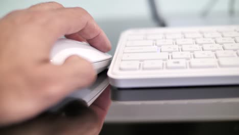 left handed computer user, left hand holds mouse, working, typing on keyboard