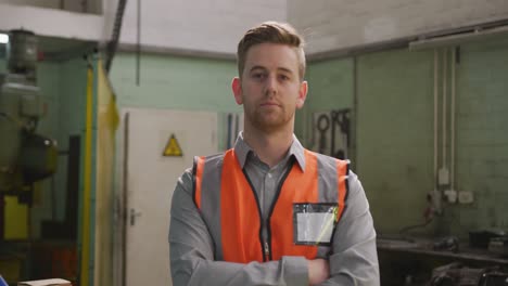 caucasian male factory worker at a factory wearing a high vis vest