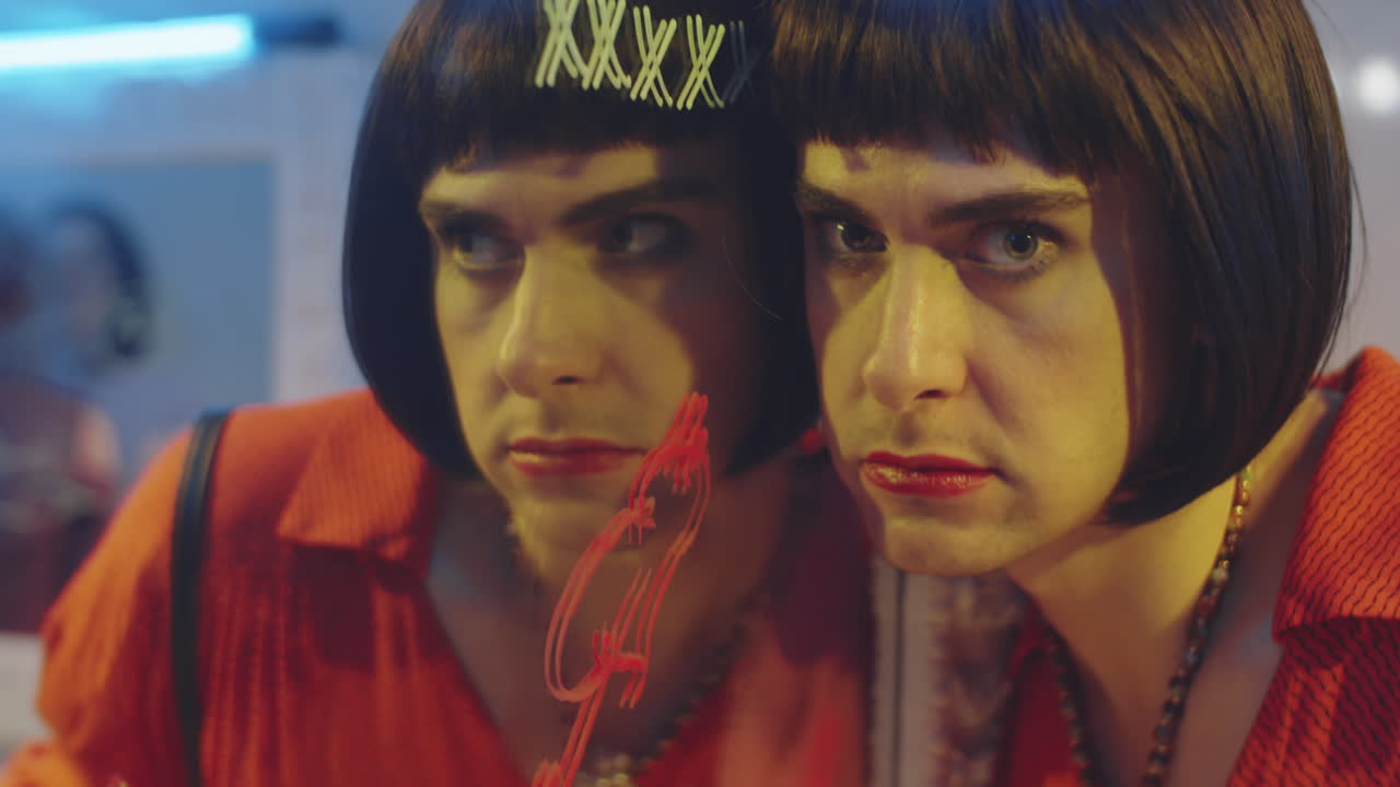 hombre transgénero posando para la cámara en el baño de un club nocturno