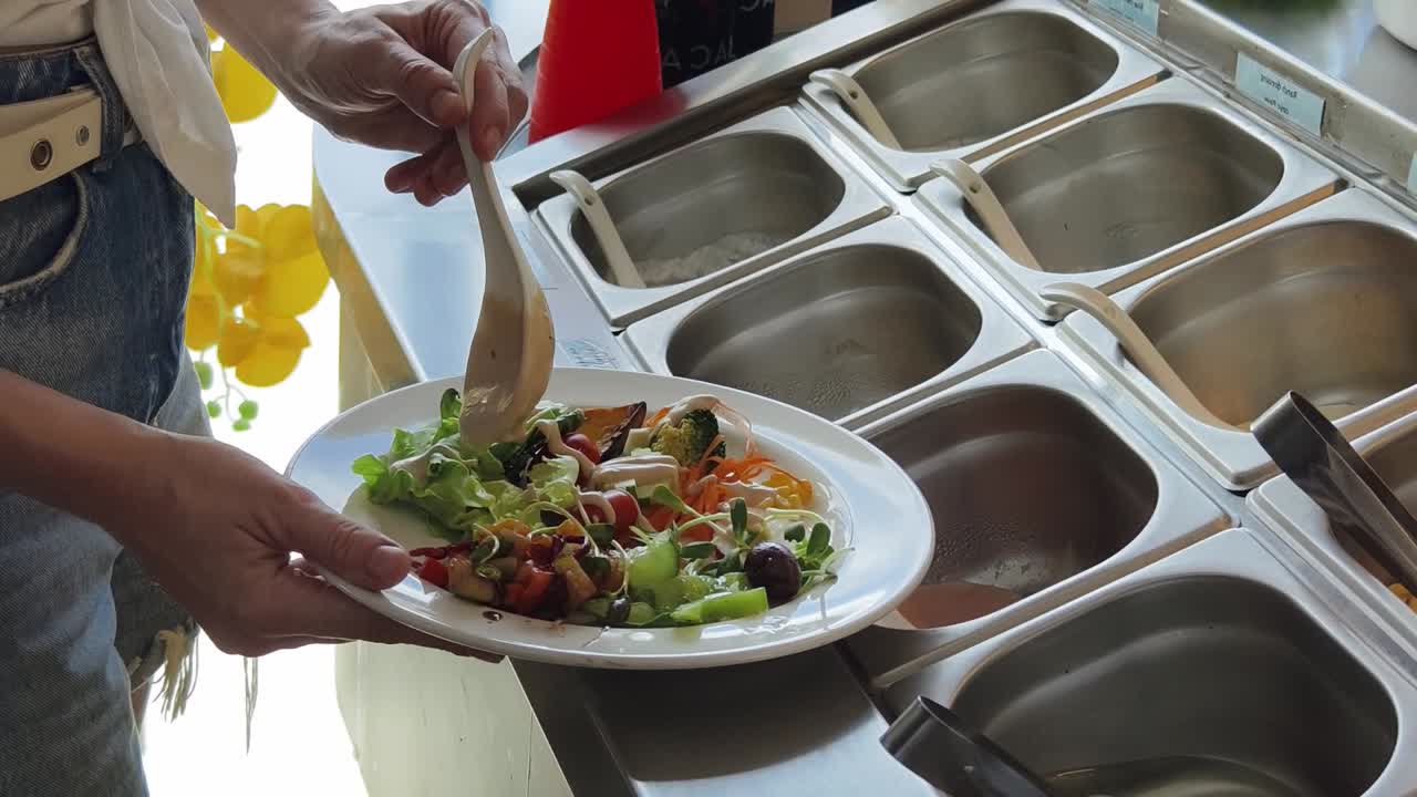 mujer haciendo una ensalada en una barra de ensalada