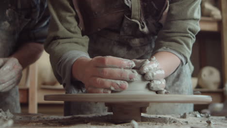 young woman enjoying wheel throwing in pottery workshop