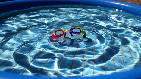 colorful swimming goggles floating in a small pool