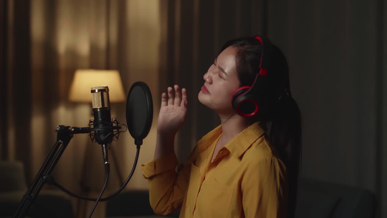 Giovane donna asiatica che canta in studio casalingo