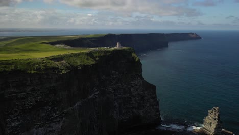 Moher-Tower-on-the-edge-of-Cliffs-of-Moher,-Ireland,-aerial-reveal