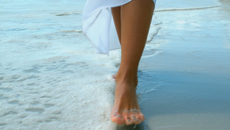 Low-section-of-woman-walking-by-the-sea-on-the-beach-4k