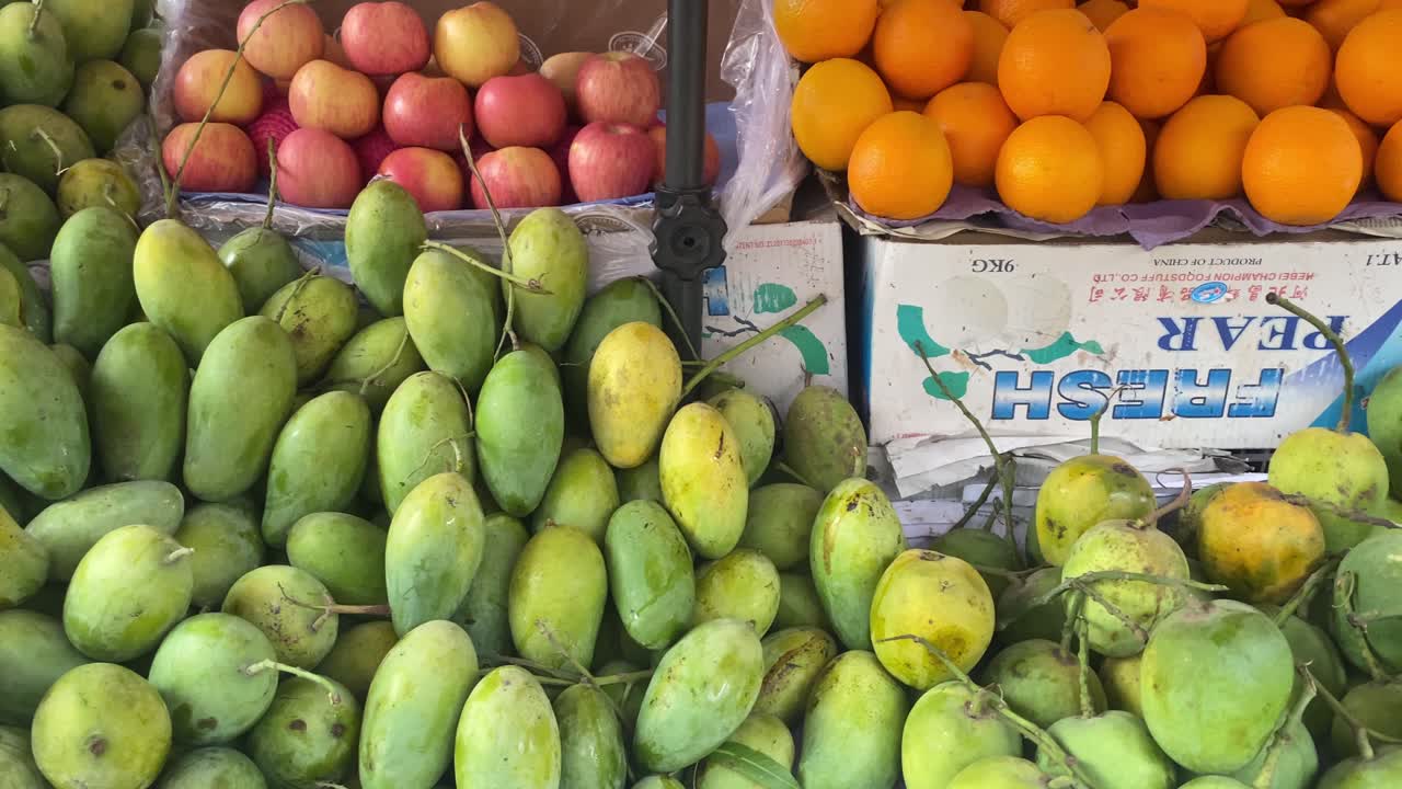 fila de mangos, naranjas y manzanas en el mercado de frutas