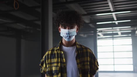 retrato de un hombre de raza mixta con una máscara de protesta en un garaje vacío