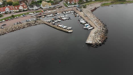 Reveal-shot-of-small-town-Arild-Sweden-during-day-time,-aerial