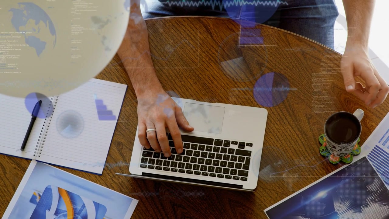 Man typing on laptop while generating blue overlays, reaching for mug as reviewing business charts
