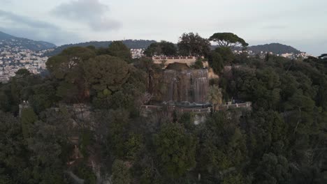 catarata en la cima de una colina en la riviera francesa junto a la vegetación y la ciudad de niza, mar mediterráneo