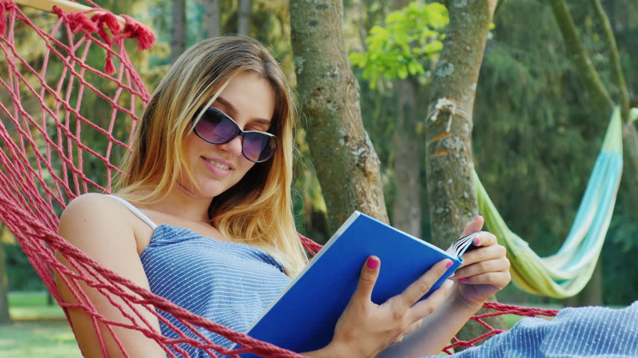 Attractive woman rests in a hammock on a summer day