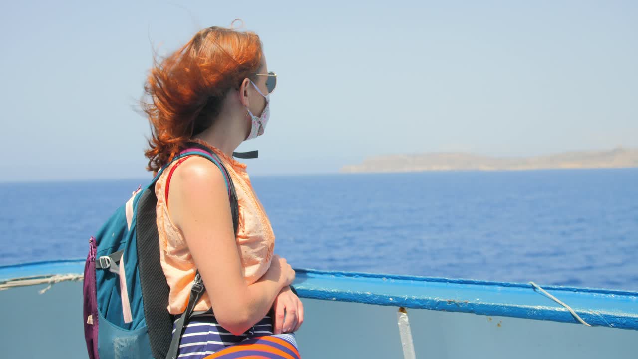 몰타에서 고조 섬까지 가는 고조 채널 라인 페리를 타고 이동하는 빨간 머리 소녀는 바다 위의 보트 앞을 바라보고 있습니다.
