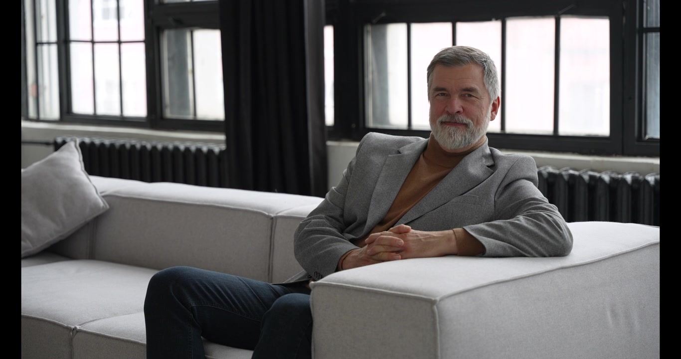Mature Businessman Sitting on Sofa in Modern Office