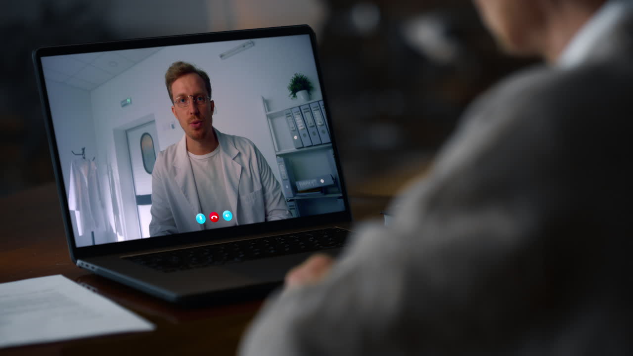 Distant woman talking videoconference laptop at dark room closeup. Lady calling