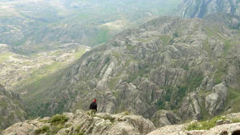 Successful-young-woman-hiker-on-mountain-top-near-a-cliff-edge