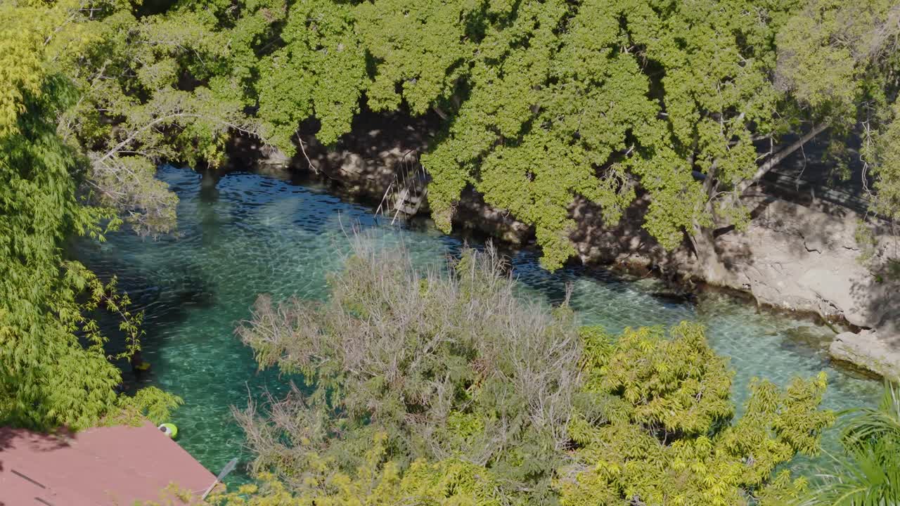 Vista aerea di una persona che nuota in un fiume turchese cristallino