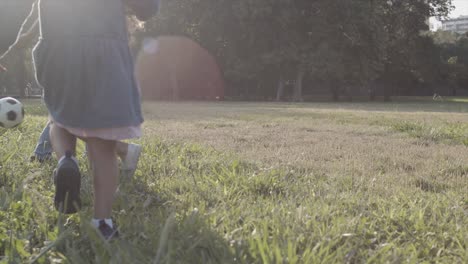 niños felices jugando al fútbol al aire libre