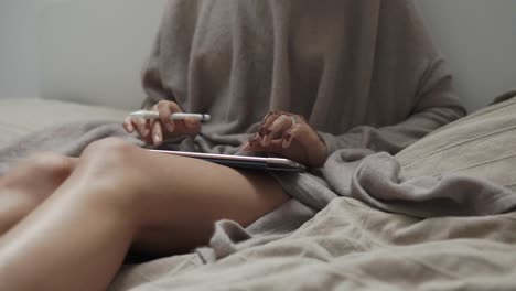 woman using tablet on bed